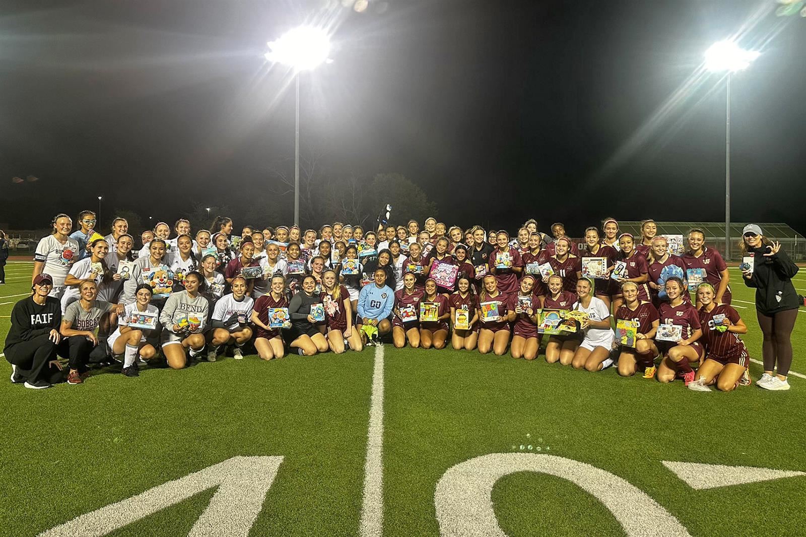 Cy-Fair and Cypress Woods girls' soccer participates in CALI BEAR toy drive.